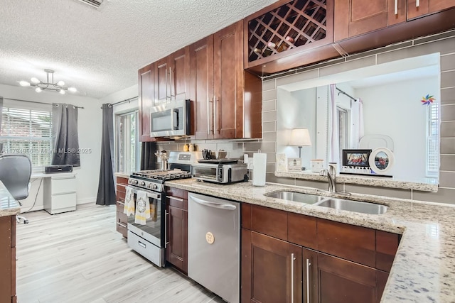 4220 NW 114th Ave, Sunrise, FL 33323 - kitchen featuring appliances with stainless steel finishes, light stone counters, a sink, light wood-style floors, and a toaster