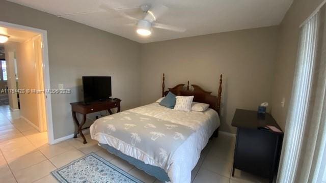 bedroom featuring baseboards, a ceiling fan, and light tile patterned flooring