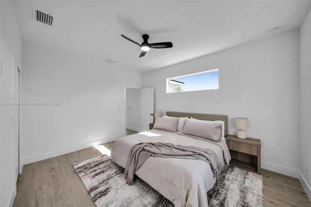 bedroom with visible vents, baseboards, ceiling fan, and wood finished floors