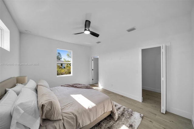 bedroom with visible vents, a ceiling fan, baseboards, and light wood-type flooring