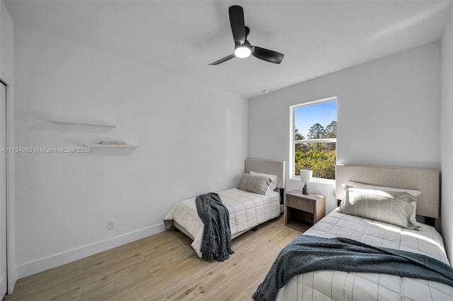 bedroom with baseboards, a ceiling fan, and wood finished floors