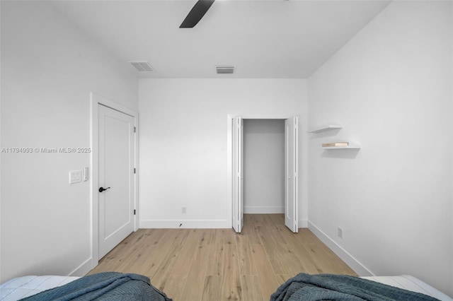 unfurnished bedroom featuring light wood-style floors, a ceiling fan, baseboards, and visible vents