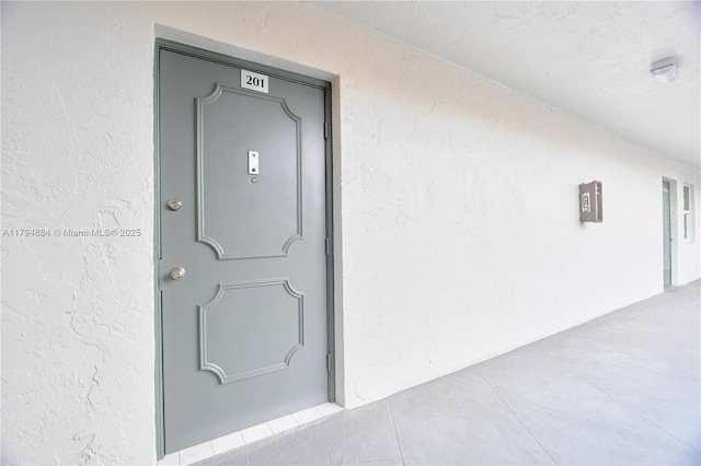 property entrance with stucco siding
