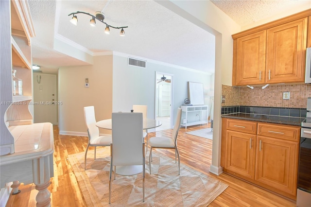 9150 Lime Bay Blvd Unit 201, Tamarac, FL 33321 - dining area featuring a textured ceiling, light wood-style flooring, ornamental molding, ceiling fan, and baseboards