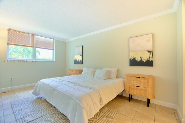 bedroom with baseboards, ornamental molding, and light tile patterned floors