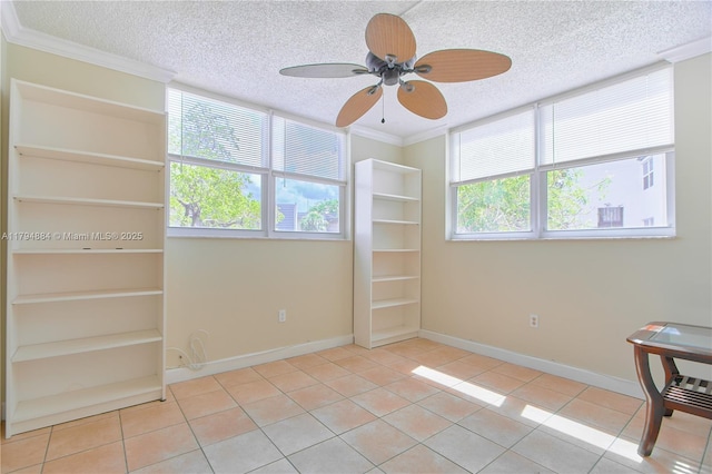 unfurnished room with a healthy amount of sunlight, ceiling fan, a textured ceiling, and crown molding