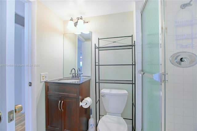 full bath featuring vanity, a shower stall, and toilet