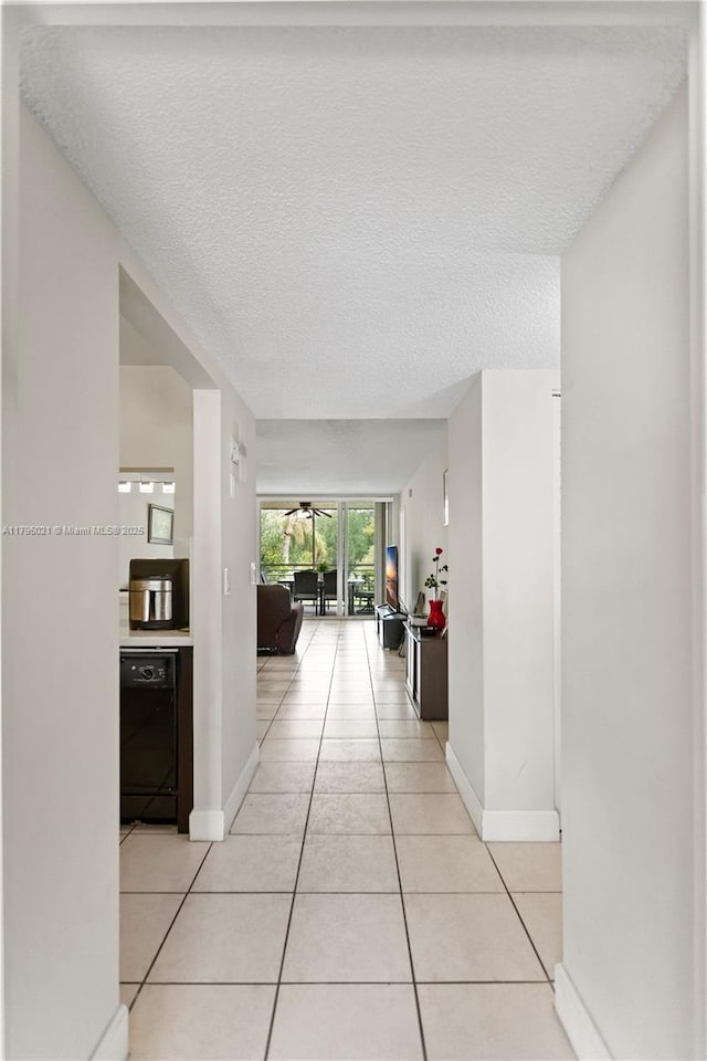 9501 Seagrape Dr Unit 205, Davie, FL 33324 - hallway featuring a textured ceiling, baseboards, and light tile patterned floors