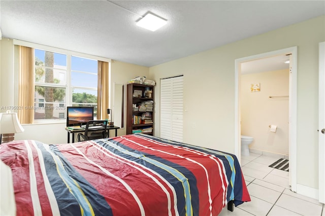 9501 Seagrape Dr Unit 205, Davie, FL 33324 - tiled bedroom featuring baseboards, a textured ceiling, and ensuite bath