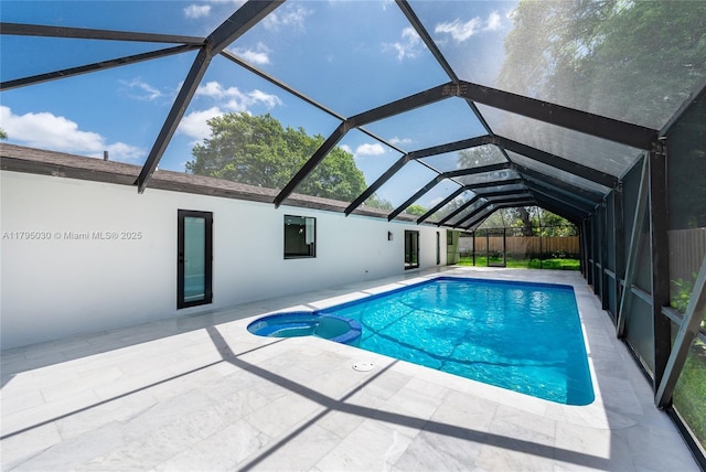 view of pool with a lanai, a patio area, a pool with connected hot tub, and fence