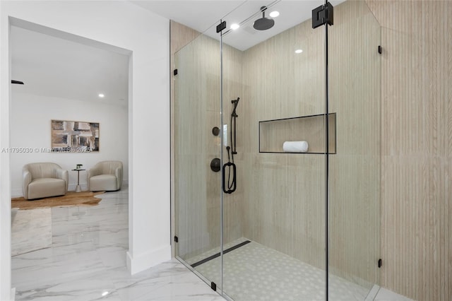 bathroom featuring baseboards, marble finish floor, and a stall shower