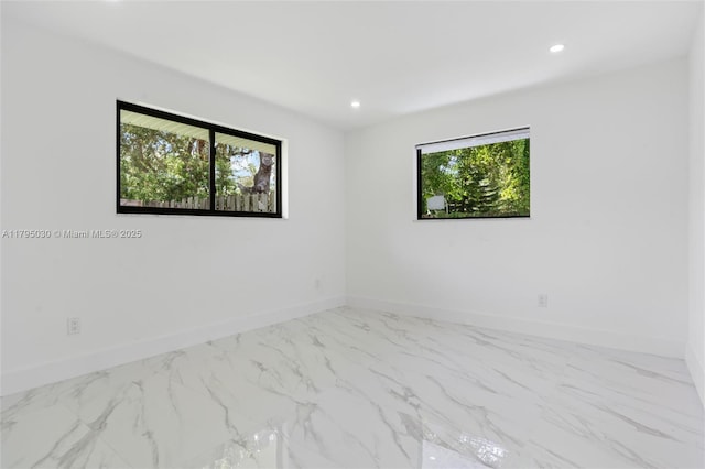 unfurnished room featuring baseboards, recessed lighting, and marble finish floor