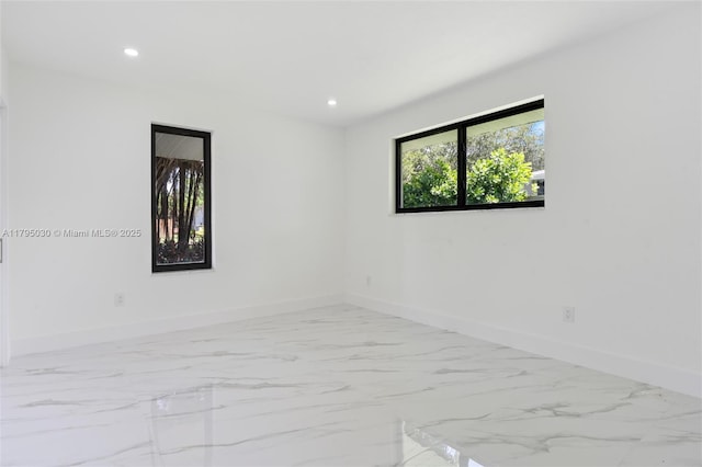 spare room featuring baseboards, recessed lighting, and marble finish floor