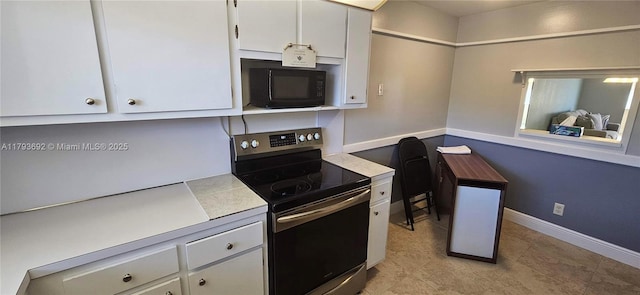 10207 Sunrise Lakes Blvd Unit 307, Sunrise, FL 33322 - kitchen featuring stainless steel range with electric cooktop, black microwave, light countertops, white cabinets, and light tile patterned floors