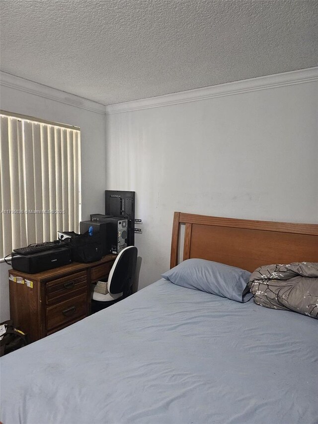 bedroom featuring ornamental molding and a textured ceiling