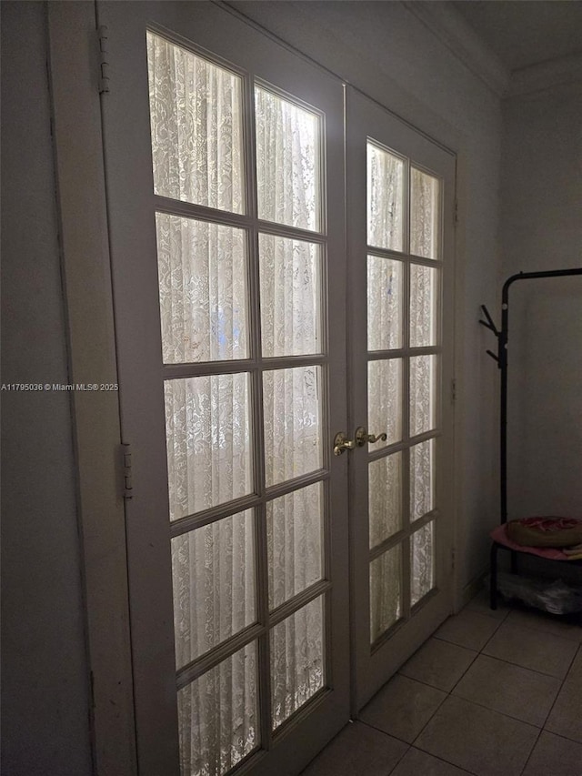 doorway featuring tile patterned floors, ornamental molding, and french doors