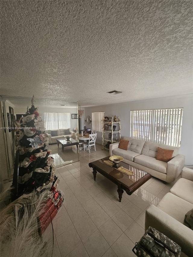 living area featuring tile patterned flooring and a textured ceiling