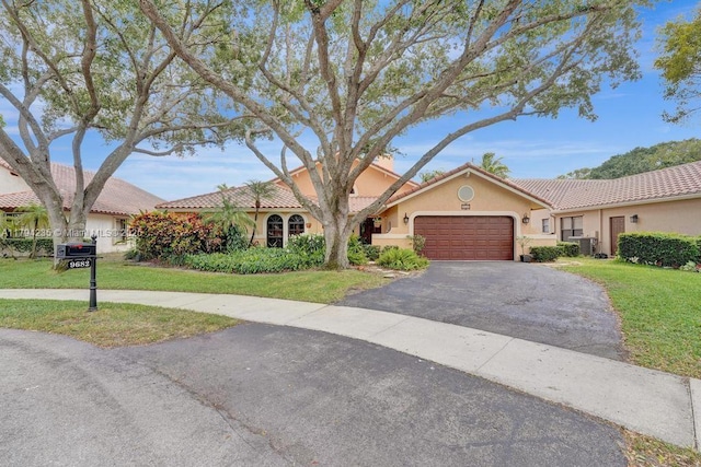 9682 Ridgecrest Ct, Davie, FL 33328 - mediterranean / spanish house featuring a garage, a front lawn, stucco siding, driveway, and a tile roof