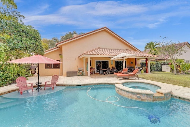 view of swimming pool featuring a patio, a pool with connected hot tub, and a yard