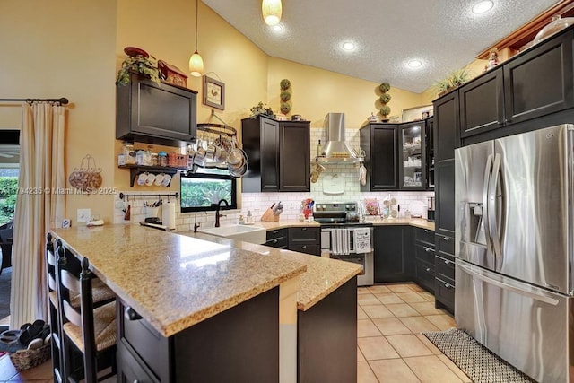 9682 Ridgecrest Ct, Davie, FL 33328 - kitchen featuring stainless steel appliances, wall chimney exhaust hood, a peninsula, a sink, and a textured ceiling