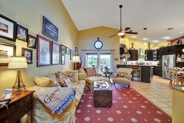 living area with high vaulted ceiling, a ceiling fan, light tile patterned flooring, and visible vents