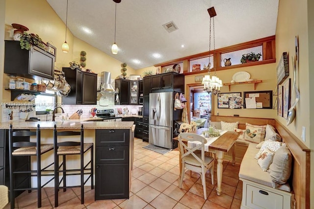 kitchen with visible vents, a notable chandelier, high vaulted ceiling, and stainless steel appliances