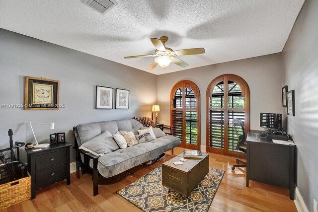 9682 Ridgecrest Ct, Davie, FL 33328 - living room featuring a ceiling fan, a textured ceiling, light wood-style floors, a desk, and baseboards