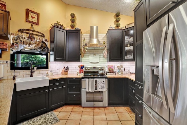 kitchen with a sink, backsplash, stainless steel appliances, and wall chimney exhaust hood