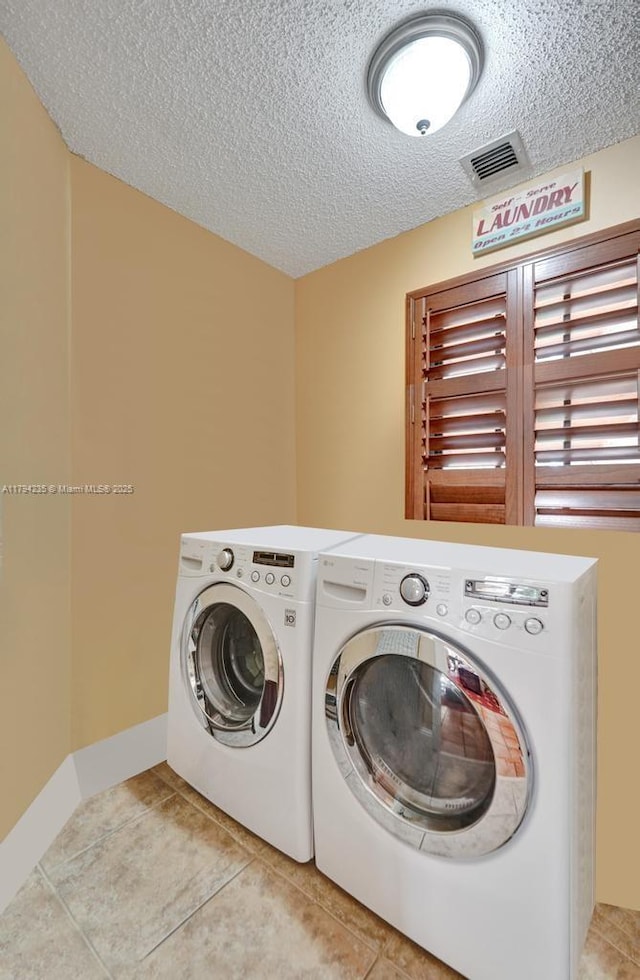 9682 Ridgecrest Ct, Davie, FL 33328 - clothes washing area featuring washer and dryer, a textured ceiling, and light tile patterned floors