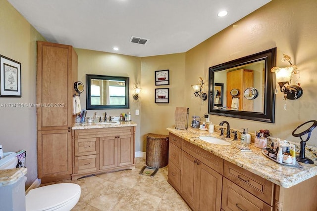 bathroom featuring a sink, two vanities, and visible vents