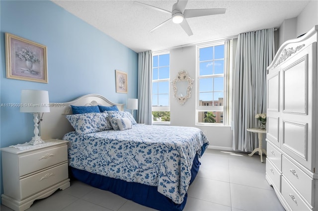 bedroom featuring ceiling fan, a textured ceiling, and light tile patterned floors