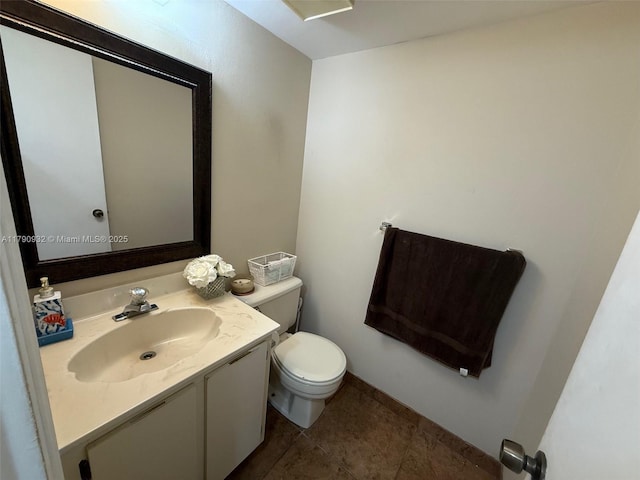 bathroom with toilet, vanity, and tile patterned flooring