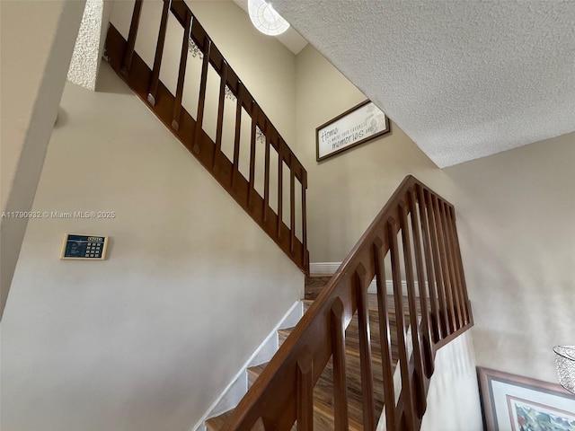 stairway featuring a textured ceiling