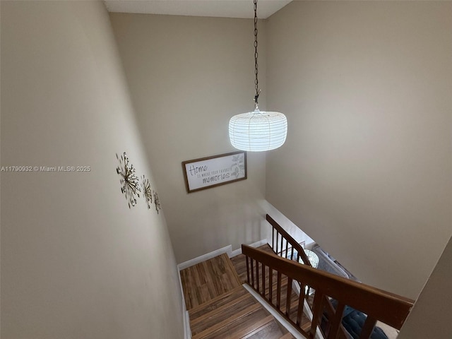 stairway featuring wood finished floors and baseboards