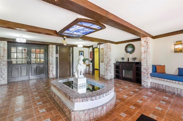 living room featuring french doors, baseboards, brick floor, and beamed ceiling