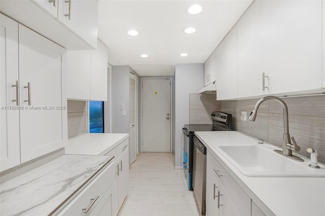kitchen with light countertops, under cabinet range hood, a sink, dishwasher, and range with electric cooktop