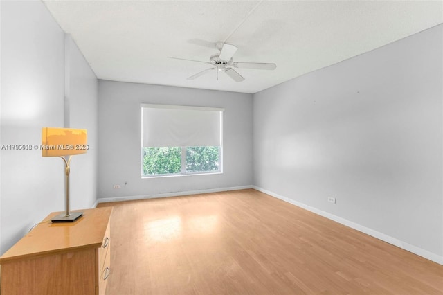 spare room with ceiling fan, baseboards, and light wood-type flooring