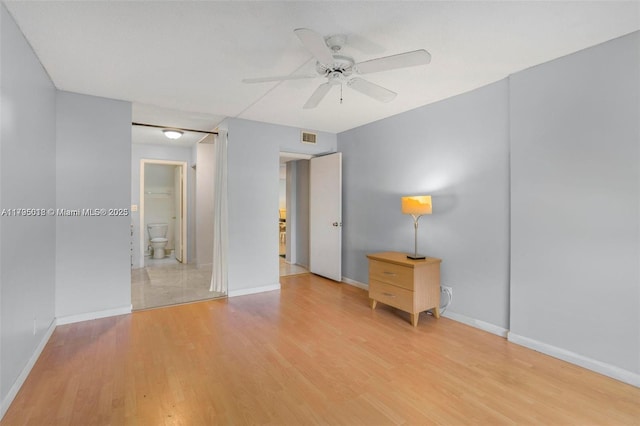 unfurnished bedroom with a ceiling fan, visible vents, light wood-type flooring, baseboards, and ensuite bathroom