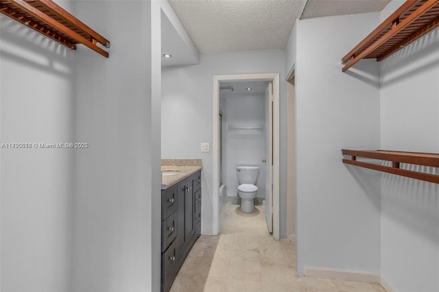 full bathroom with a textured ceiling, vanity, baseboards, toilet, and recessed lighting