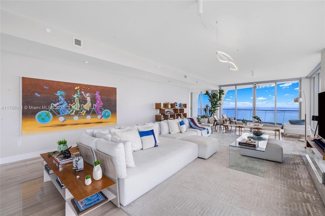 living area featuring wood finished floors, baseboards, expansive windows, and visible vents