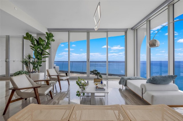sunroom featuring a water view
