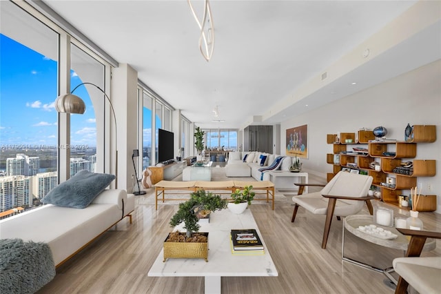 living area with expansive windows, a city view, and light wood-type flooring