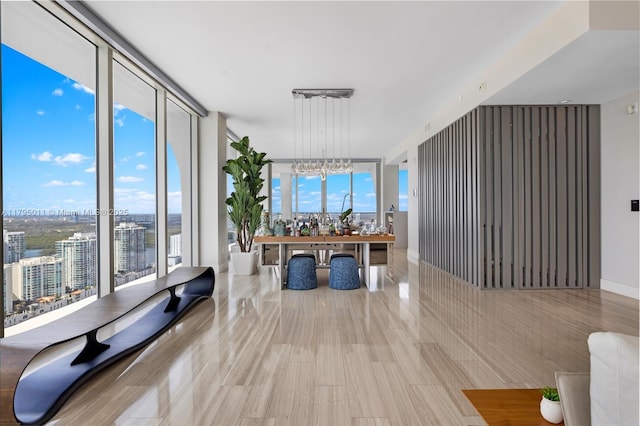 interior space with a wall of windows, a view of city, a wealth of natural light, and a chandelier