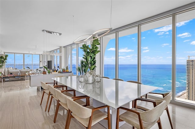 dining area featuring a water view and a wall of windows