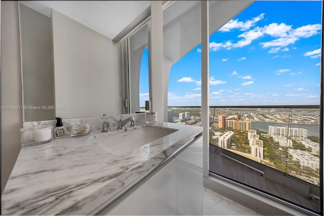 bathroom with vanity, a city view, marble finish floor, and lofted ceiling