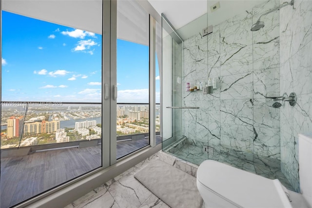 full bathroom featuring a view of city, toilet, a marble finish shower, and marble finish floor