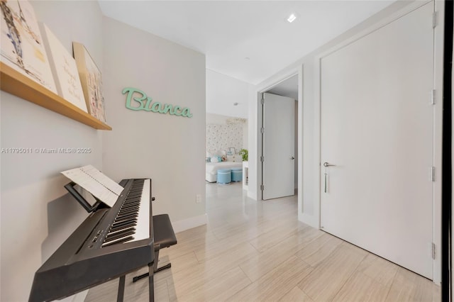 hall with light wood-type flooring and baseboards