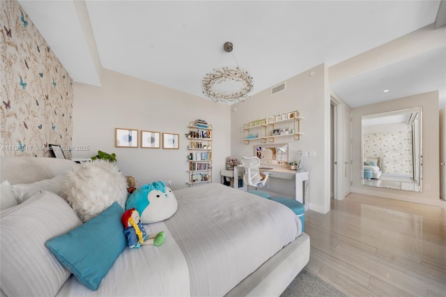 bedroom featuring baseboards, visible vents, and wood finished floors