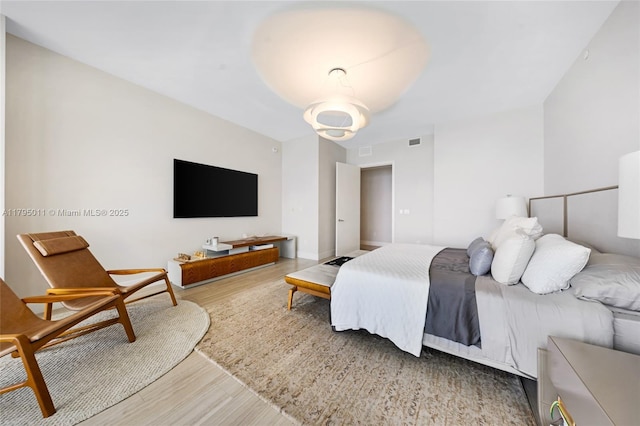 bedroom featuring visible vents and wood finished floors