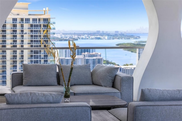 balcony featuring a view of city, a water view, and an outdoor hangout area